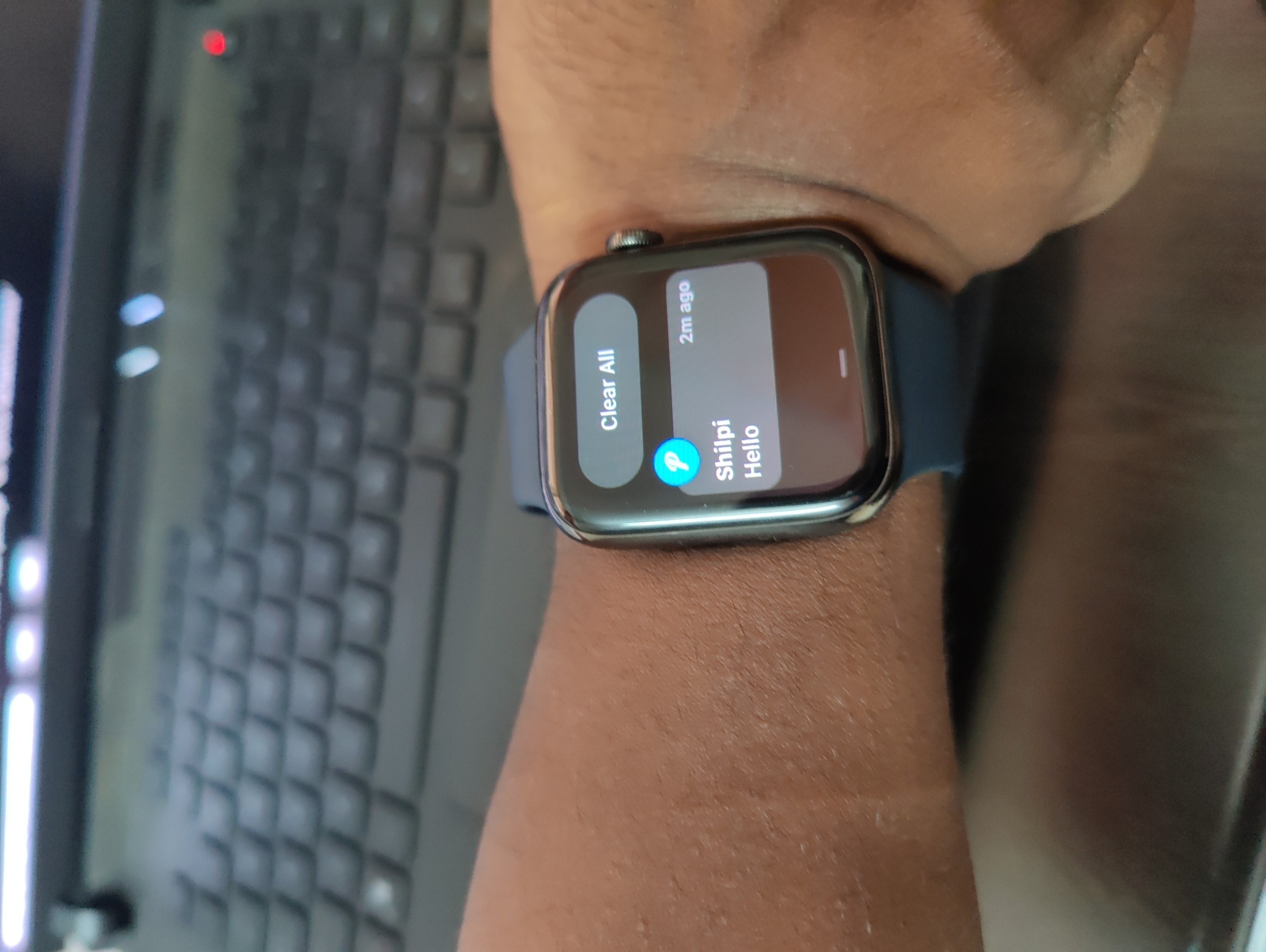 Apple Watch on hand showing a message reading hello from shilpi